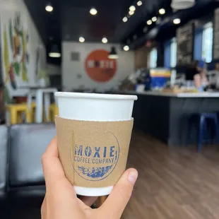 a hand holding a coffee cup