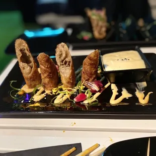 a plate of appetizers and dipping sauce