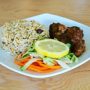 a plate of rice, meat and vegetables