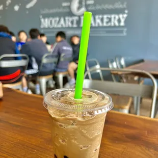 a cold beverage in a plastic cup with a green straw