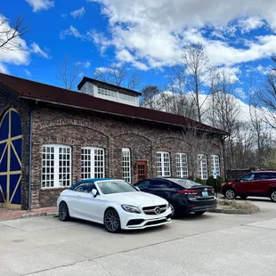 two cars parked in front of a brick building