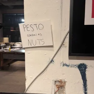 a sign on a wall that says pesto coming nuts