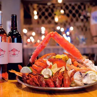 a plate of crab legs and a bottle of wine