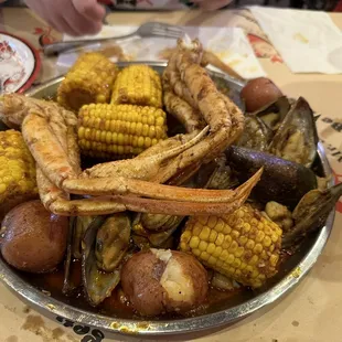 Crabs, potato, green muscles, scallops, and corn