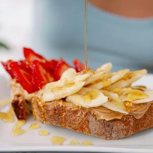  woman pouring syrup onto a sandwich