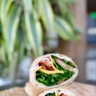 a wrap with bacon, cheese, and spinach