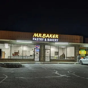 the front of a bakery at night