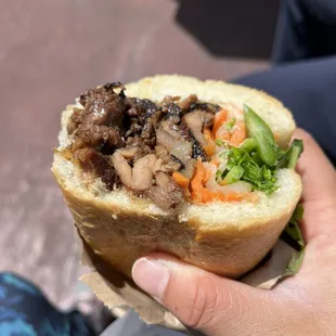 a person holding a sandwich