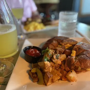 Ham, eggs and cheese croissant with home fries.