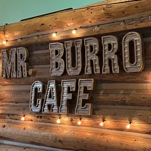 a rustic sign with string lights