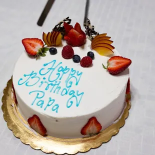 a white cake with blue frosting and strawberries