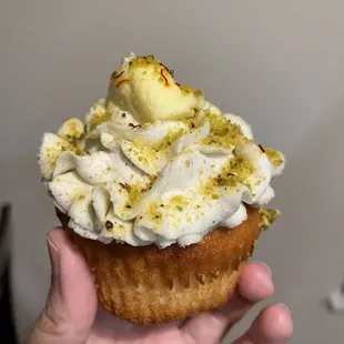 a hand holding a cupcake