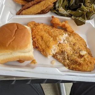 Fried catfish, potato wedges, collard greens, and a roll