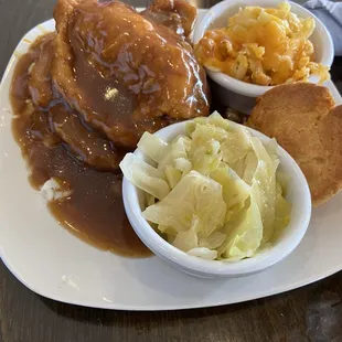 Smothered pork chops with rice and gravy, cabbage, Mac/cheese with cornbread.