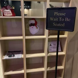 a sign that reads please wait to be seated
