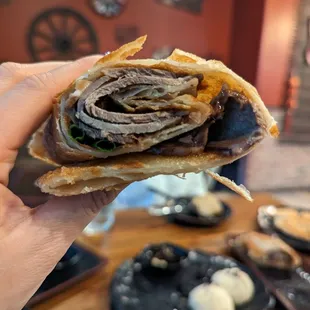 a person holding a sandwich