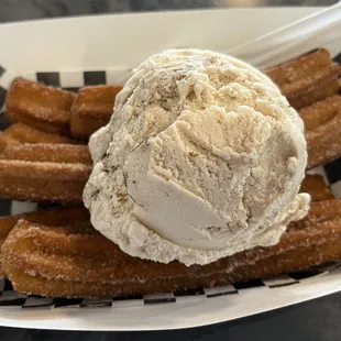 a scoop of ice cream in a basket of churros