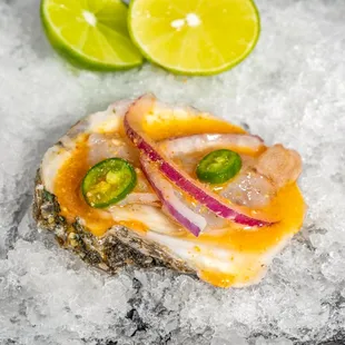 an oyster with onions, jalapenos, and lime