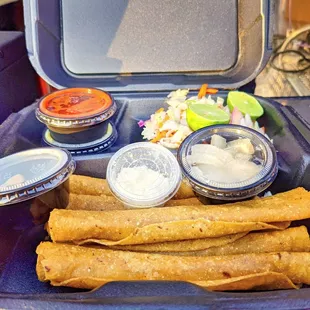 a tray of tacos and sauces