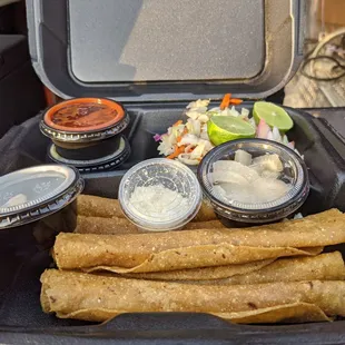 a tray of tacos and sauces