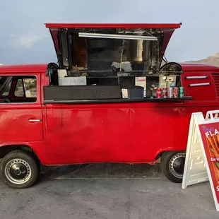 a red vw bus parked in a parking lot