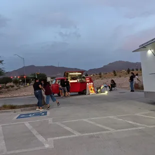 a group of people standing in front of a food truck
