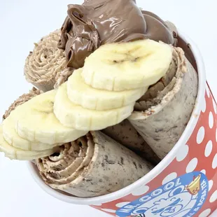 a cup of ice cream with chocolate and banana slices