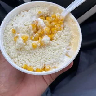 Corn in a cup with crumbled cheese, butter, mayo. Hot sauce not pictured