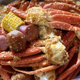 a pile of crab legs, corn, and sausage