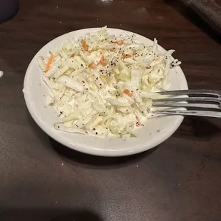 a white plate of coleslaw