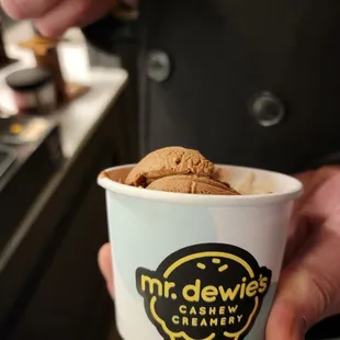 a person holding a cup of ice cream