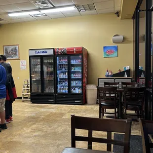 a man and a woman standing in front of a vending machine