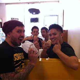 a group of men eating donuts