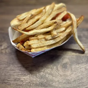 Steak sandwich covered by a bedding of thick cut fries