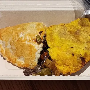 One half of a beef pasty and half of a mushroom pasty