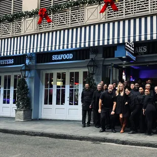a group of people standing in front of a restaurant