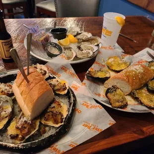 two plates of oysters and a sandwich