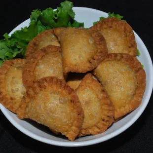 a plate of empanadas with lettuce