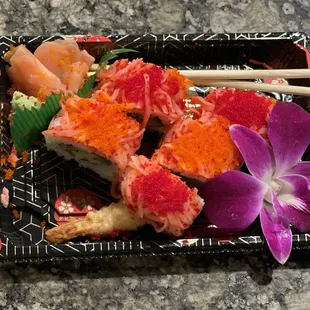 a plate of sushi with chopsticks