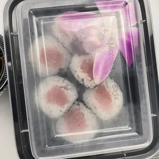 a plastic container filled with sushi