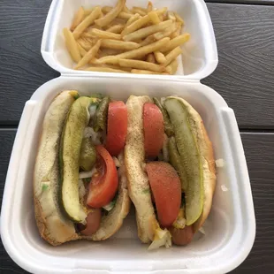 Chicago dog w all beef hot dog, sport peppers, celery salt , wedge pickle, bright green relish and tomato wedges.