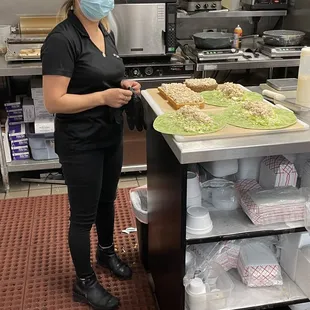 a woman in a kitchen with a mask on