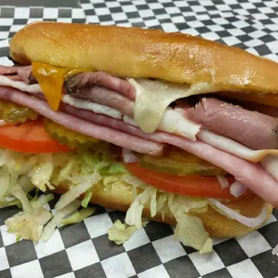 a sub sandwich on a checkered tablecloth