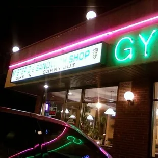 a neon sign in front of a restaurant