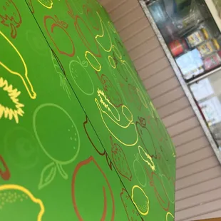 a close up of a green wall with a bunch of fruit on it