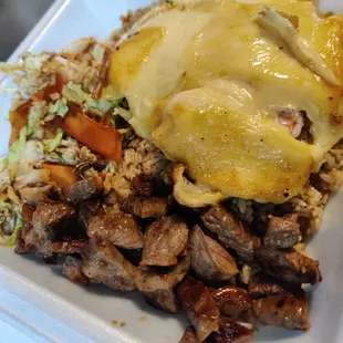 Hibachi steak and shrimp with egg yolk sauce on top.