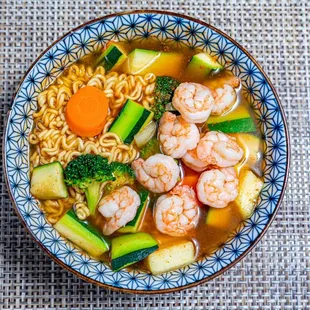  a bowl of ramen with shrimp and vegetables