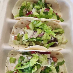 three tacos in a styrofoam container
