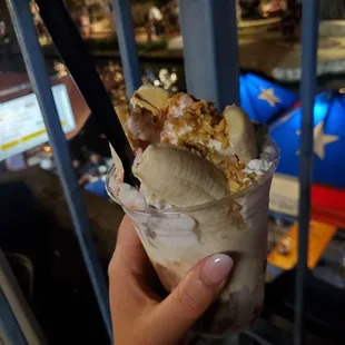 a hand holding a scoop of ice cream