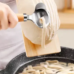 ws a person stirring noodles in a skillet